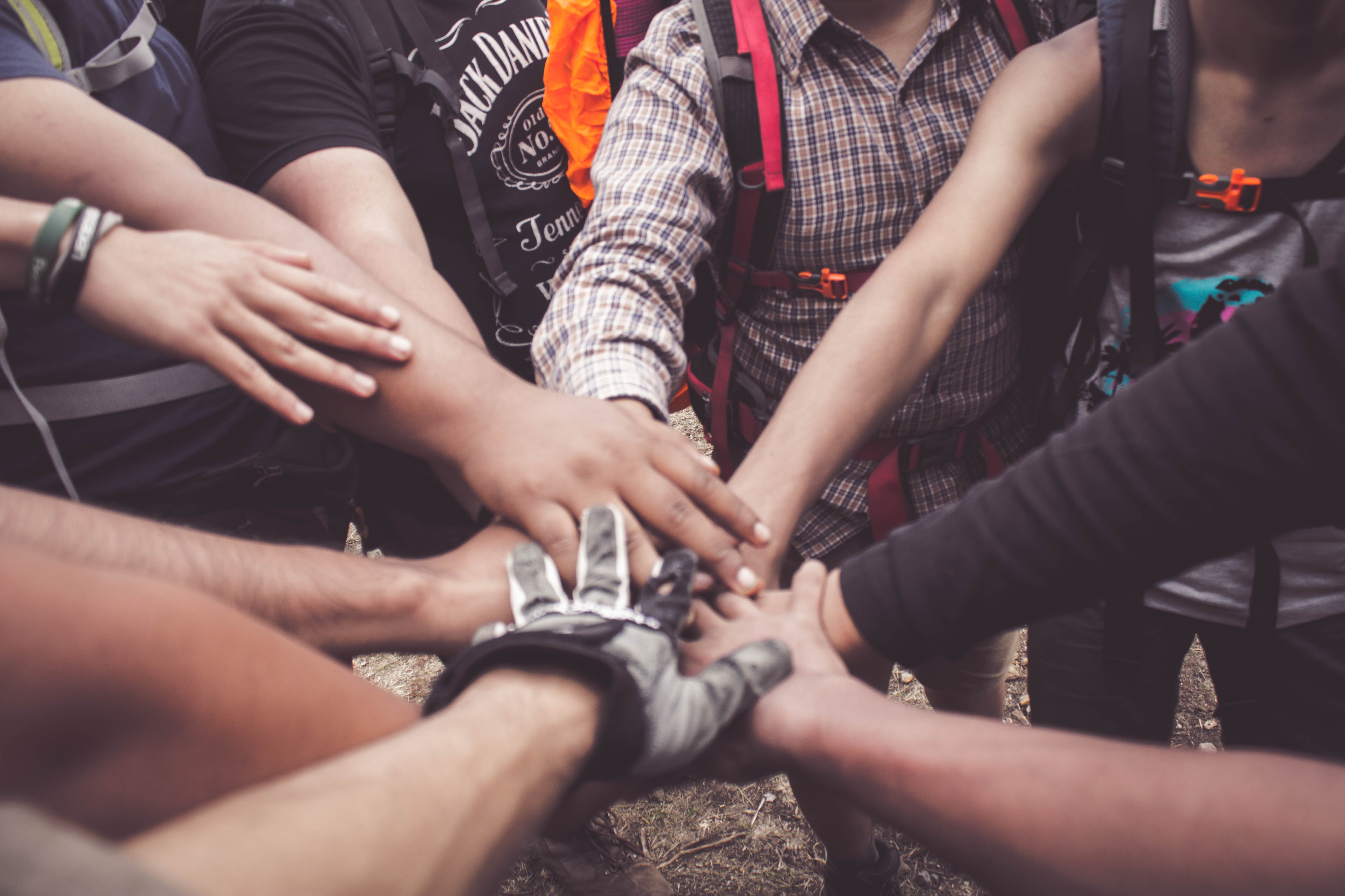 A group of people put their hands together in a circle.